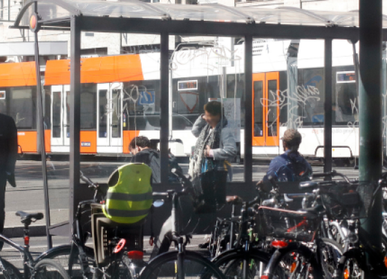 Photo d'un parking vélo à un arrêt de bus, avec un tram tpg